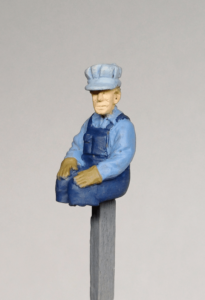 Painting a model locomotive driver.