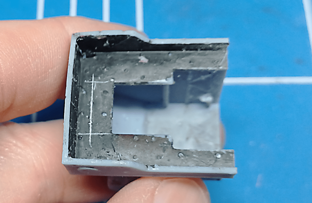 Modifying a model locomotive body so the chassis fits. 