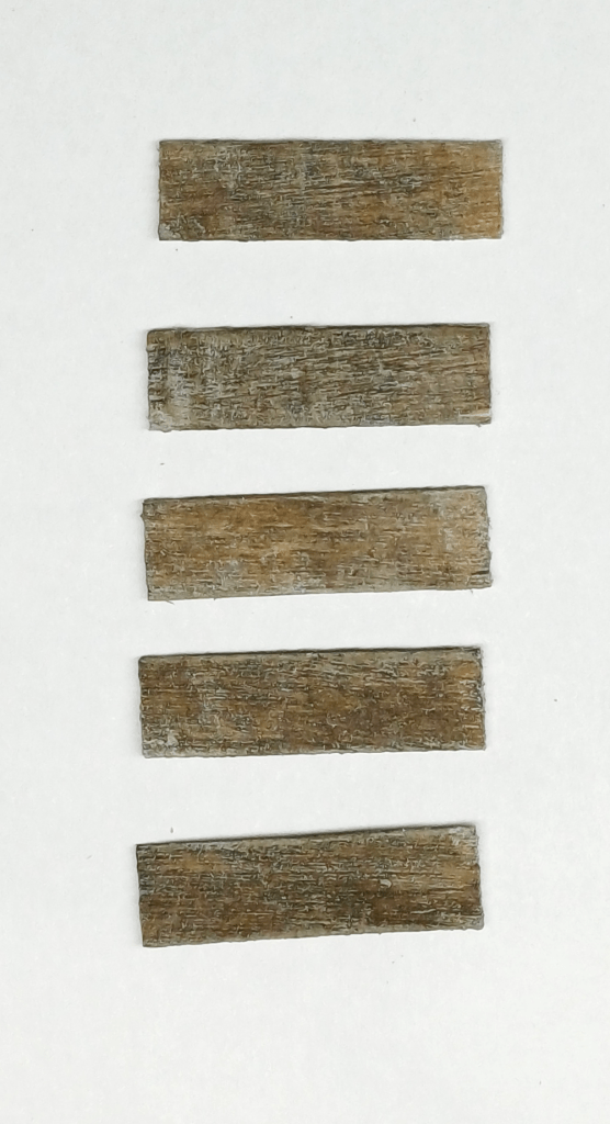 Painting coffee stirrers to make them look like aged wood for a model railway