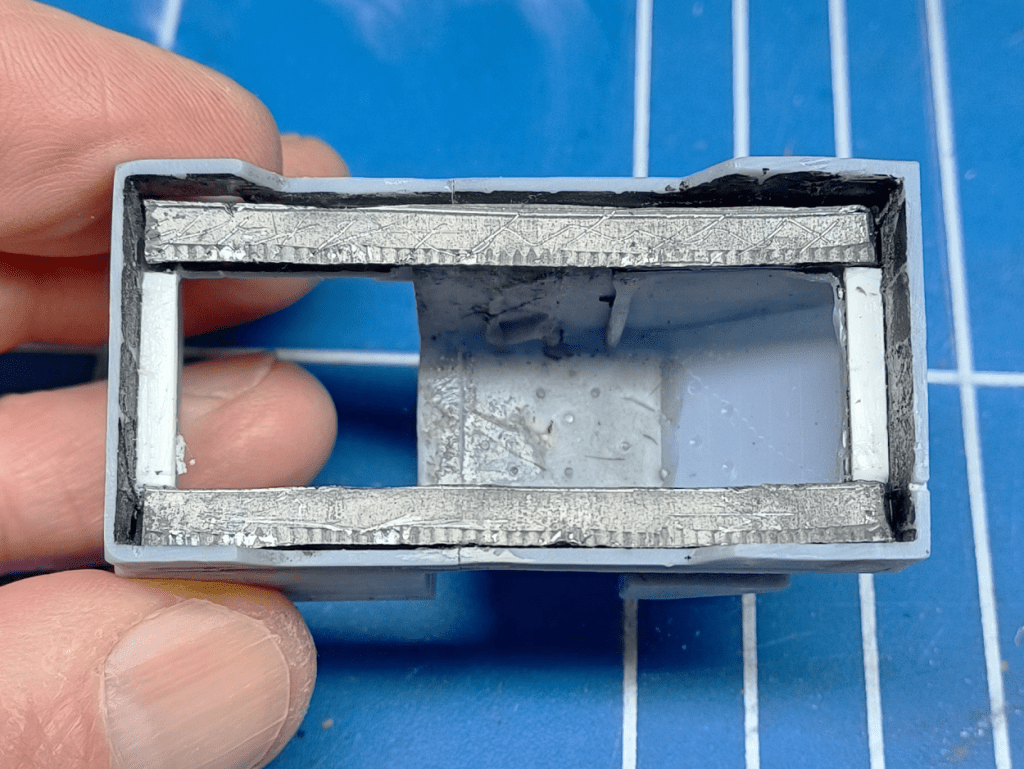 Modifying a 3D printed model locomotive body by adding lead weights.