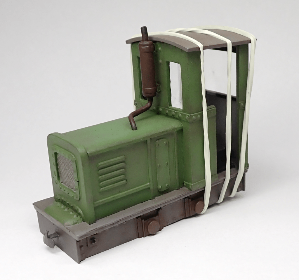 Elastic bands hold the cab roof of an O9 On18 narrow gauge locomotive in place while the glue dries